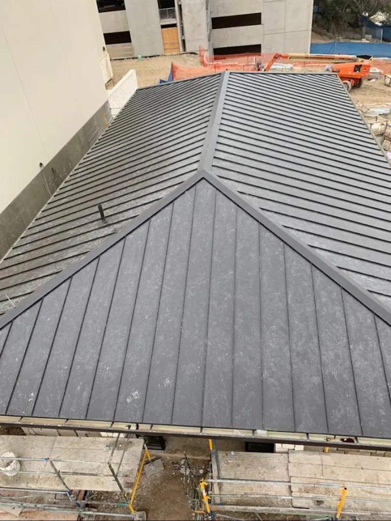 Commercial metal roof construction with crane equipment in Kimball