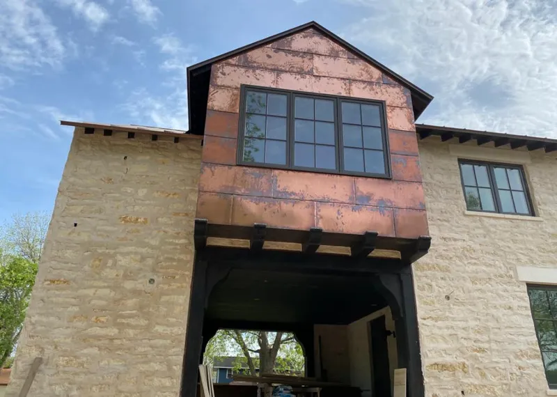 Copper metal panel facade on a stone building for Skylight Installation in Kimball